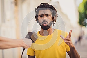 Photo portrait of young man talking on microphone with journalist making reportage explaining news