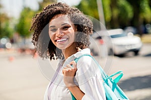 Photo of positive adorable lady wear white shirt rucksack enjoying sunny weather walking college outside urban city park
