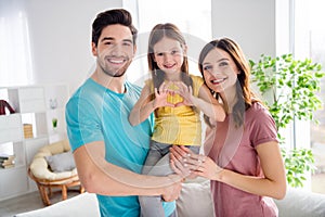 Photo of positive cheerful three people family portrait daddy carry little daughter kid girl make heart sign cuddle