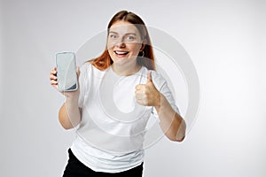 Photo of positive confident woman holding modern device and showing thumb up isolated white background. 30s girl showing