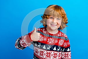 Photo of positive cool small boy wear ornament sweater pointing showing thumb up enjoying xmas isolated blue color