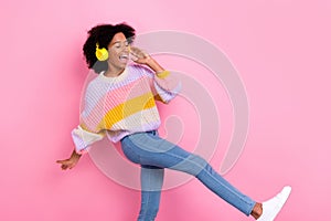Photo of positive funny good mood girl with perming coiffure dressed knit sweater headphones dancing isolated on pink