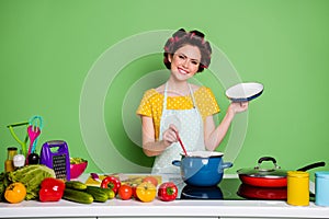 Photo of positive girl prepare tasty ecological gourmet supper open cover saucepan wear hair rollers yellow dotted t