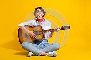 Photo of positive girl professional guitarist wear stylish clothes sitting floor looking empty space isolated on yellow