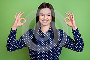 Photo of positive girl show okey signs approve recommendation wear dotted blouse isolated on green color background