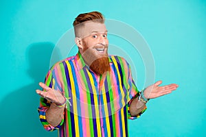 Photo of positive glad man wear bright fashionable clothes shrug shoulders no answer isolated on cyan color background