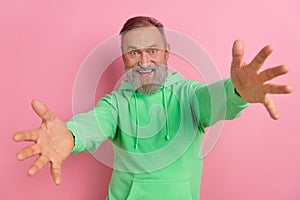 Photo of positive impressed man wear green sweatshirt open arms ready hug you isolated pink color background