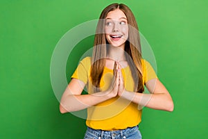 Photo of positive nice girl toothy smile hands palms plead look empty space  on green color background