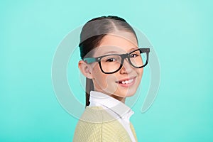 Photo of positive nice school girl shiny beaming smile wear specs green top cardigan  turquoise color background