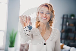 Photo of positive peaceful girl toothy smile arm hold demonstrate key bright living room new house inside