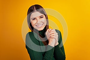 Photo of positive relaxed cute lady hold hands enjoy dream wear green shirt isolated on yellow background