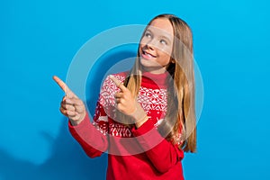 Photo of positive schoolgirl with straight hairdo dressed sweater directing look at disocunt empty space  on