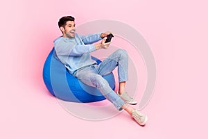 Photo of positive stylish man have relax rest home free time playing gta game empty space isolated on pink color