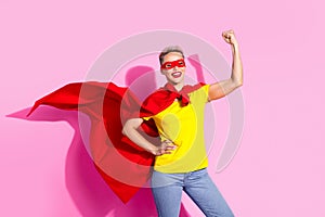 Photo of positive super lady wear red cape hand flexing showing biceps isolated on pink color background