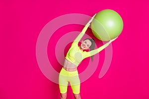 Photo of positive young sportswoman bend fit ball aside stretching back isolated over pink shine color background