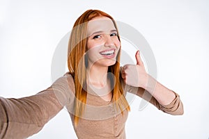 Photo of pretty adorable redhair woman beige shirt recording video showing thumb up smiling isolated white color