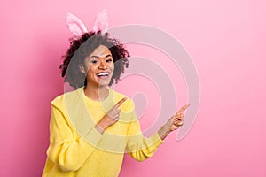 Photo of pretty adorable woman dressed kitted pullover easter headband pointing empty space isolated pink color