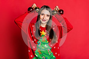 Photo of pretty adorable young lady wear ornament sweater holding arms gold christmas balls smiling isolated red color