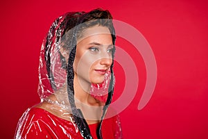Photo of pretty adorable young woman dressed rubber coat hood smiling looking empty space isolated red color background