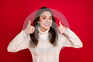 Photo of pretty adorable young woman dressed white sweater smiling showing two thumbs up isolated red color background