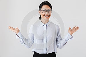 Photo of pretty businesswoman wearing eyeglasses laughing while standing in the office, isolated over white background