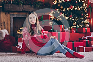 Photo of pretty charming young woman dressed red sweater sitting floor celebrating new year smiling indoors room home