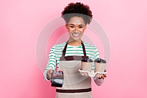 Photo of pretty cheerful cashier girl hold barista coffee ask payment wear apron striped shirt isolated pink color