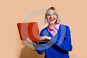Photo of pretty cheerful girl toothy smile use wireless laptop chatting isolated on beige color background