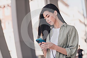 Photo of pretty cute lady dressed casual clothes typing modern device enjoying sunshine outside urban town house