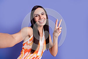 Photo of pretty cute lady wear dress recording video showing v-sign isolated purple color background