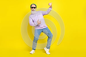Photo of pretty cute mature man dressed purple pullover headwear spectacles dancing playing guitar isolated yellow color