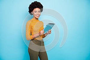 Photo of pretty dark skin wavy lady hold e-book hands reading online book modern technology user wear yellow striped