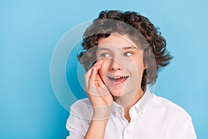 Photo of pretty excited school boy wear white shirt arm lips looking empty space smiling isolated blue color background