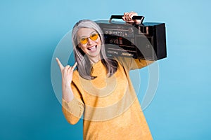 Photo of pretty hipster rocker aged woman excited look open mouth hold boom box walk street listen rock-n-roll loud show