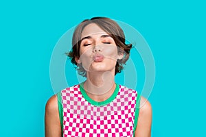 Photo of pretty lovely cute girl closed eyes sending you sweet air kiss isolated on cyan color background