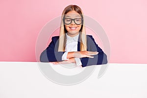 Photo of pretty lovely little lady schoolkid beaming smiling look down white wall empty space interested study products