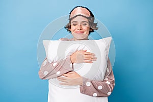 Photo of pretty lovely young woman enjoy sleep hold hug pillow soft isolated on blue color background