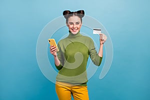 Photo of pretty millennial lady hold telephone plastic credit card advising cool service online payment buy wear green