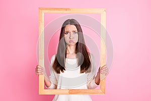 Photo of pretty offended young lady wear white shirt bloated cheeks holding brown portrait frame  pink color