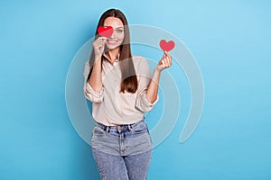 Photo of pretty plauful lady wear trendy outfit eye closed raise arm present show red paper symbol heart  on