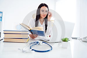 Photo of pretty professional doc lady hold science literature attentively reading symptoms of rare disease look notebook