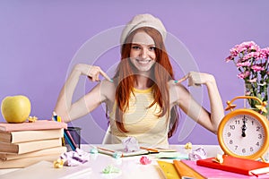 Photo of pretty student girl pointing finger at herself while sitting at desk