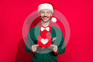 Photo of pretty sweet guy dressed xmas green cardigan holding heart like card enjoying noel isolated red color