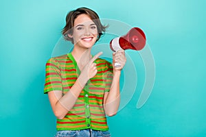 Photo of pretty sweet lady wear striped cardigan pointing finger loud speaker empty space isolated teal color background