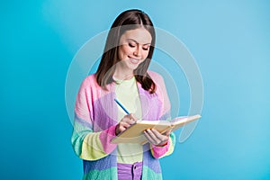 Photo of pretty young woman write look copybook creative project isolated on shine blue color background