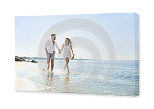Photo printed on canvas, white background. Happy young couple running on beach near sea
