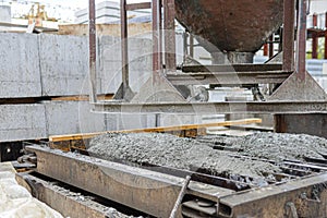 Photo of the production of reinforced concrete lintels, pouring the preheated metal mold with concrete.