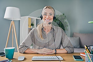 Photo of professional adviser secretary lady sit desk use mic headset video call partners in modern workspace