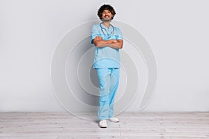 Photo of professional doctor guy standing with crossed hands isolated grey color background