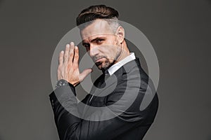 Photo in profile of elegant adult man 30s in black suit looking